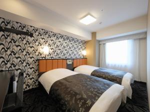 una camera d'albergo con due letti e una finestra di APA Hotel Nihombashi Bakuroyokoyama Ekimae a Tokyo