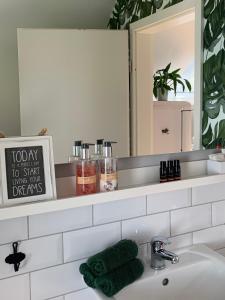 een wastafel met een spiegel en een groene handdoek bij Sascha´s Home in Saarlouis