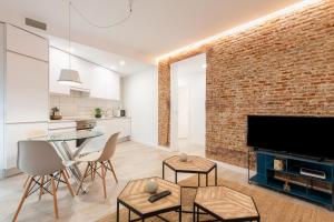 a living room with a brick wall and a glass table at Bright and modern- 2 bedrooms 1bathroom- MintyStay - Bocángel in Madrid