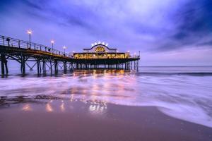 a pier with a building on the water at night at Mablethorpe Static Holiday Home in Mablethorpe