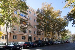 un gran edificio rosa con coches aparcados en un aparcamiento en 2 bedrooms 2 bathrooms furnished - Bernabeu - Business area with terrace - Minty Stay, en Madrid