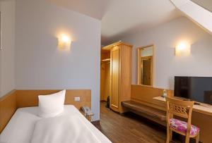 Habitación de hotel con cama y TV en Drexel´s Parkhotel en Memmingen