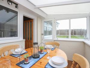 a dining room with a wooden table and chairs at Fern Hill Cottage in Llanfairpwllgwyngyll