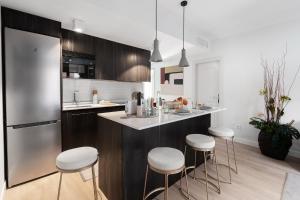 a kitchen with a counter and stools in a kitchen at Luxury and cozy- 2 bedrooms 2 bathrooms -MintyStay- Herradores in Madrid