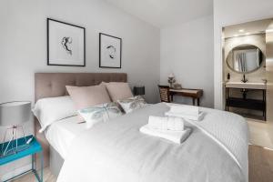 ein Schlafzimmer mit einem großen weißen Bett mit Handtüchern darauf in der Unterkunft Luxury and cozy- 2 bedrooms 2 bathrooms -MintyStay- Herradores in Madrid