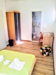 - une chambre avec un lit vert et une salle de bains dans l'établissement Maja rooms, à Split