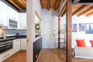 eine Küche und ein Wohnzimmer mit weißen Wänden und Holzbalken in der Unterkunft MintyStay - Hernán Cortés in Madrid