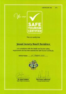 a green certificate with a sign that says safe tourism certified at Yasad Residence in Anse Possession