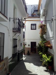 an alley between two buildings with balconies and flowers at Casa Sonrisa in Guaro