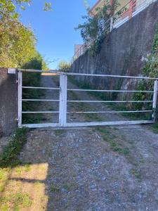une clôture à côté d'un mur en béton avec des escaliers dans l'établissement Casa do Geres ( Rio Caldo / S.Bento ), à Gerês