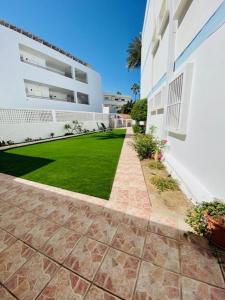 a courtyard of a building with a grass yard at Apartamentos Sandra in Playa del Ingles