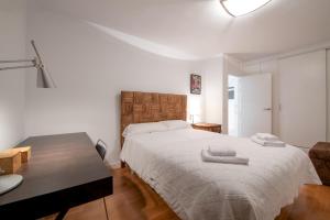 een slaapkamer met een groot bed en 2 handdoeken bij MintyStay - Felipe Campos in Madrid