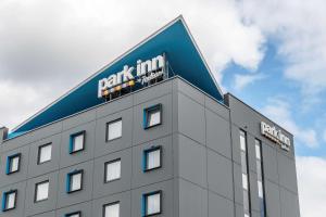 a building with a sign on the top of it at Park Inn by Radisson Vilnius Airport Hotel & Conference Centre in Vilnius