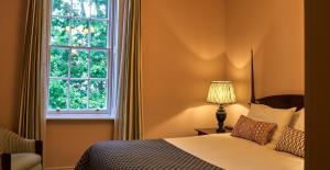 a bedroom with a bed and a window at The Mitre, Hampton Court in Kingston upon Thames