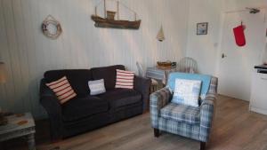 a living room with a couch and two chairs at Claremont House Holiday Apartments in Llandudno