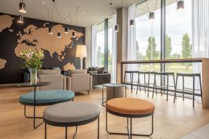 a lobby with tables and chairs and a world map on the wall at Park Inn by Radisson Vilnius Airport Hotel & Conference Centre in Vilnius
