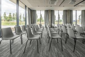 a row of chairs and tables in a room at Park Inn by Radisson Vilnius Airport Hotel & Business Centre in Vilnius
