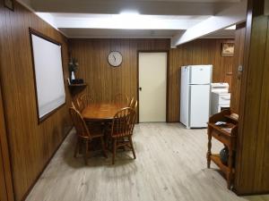 a dining room with a table and chairs and a white refrigerator at Huntinaddi Lodge in Halls Gap