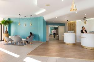 a rendering of a lobby with people sitting at a table at Hôtel Les Jardins De Sainte-Maxime in Sainte-Maxime