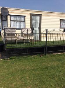 a porch with a table and chairs in front of a house at L&g FAMILY HOLIDAYS 4 BERTH CORAL BEACH GEN FAMILYS ONLY AND LEAD PERSON MUST BE OVER 30 in Ingoldmells