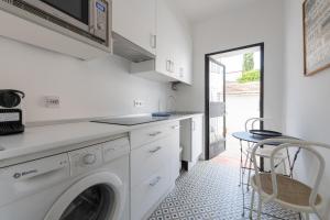 a kitchen with a washing machine and a table at MintyStay - Alhelíes in Madrid