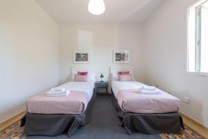 2 bedden in een kamer met witte muren en roze kussens bij MintyStay - Alhelíes in Madrid
