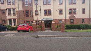 a red car parked in front of a building at Orchard Apartment in Edinburgh