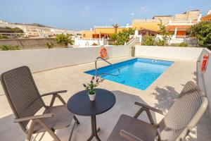 un patio con mesa y sillas y una piscina en Casa Marjoes - 2 Villas - BBQ - Communal Pool, en Moya