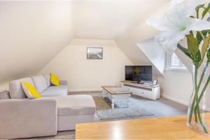 a living room with a couch and a tv at Guest Homes - Hillbrook House Dwelling in Great Malvern