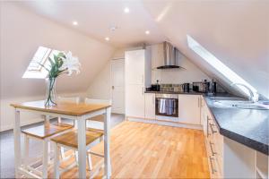 una cocina con una mesa con un jarrón de flores. en Guest Homes - Hillbrook House Dwelling en Great Malvern