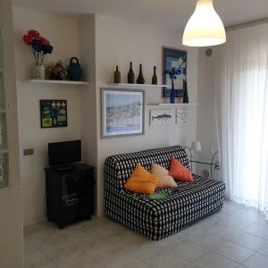 a living room with a couch with pillows on it at Accogliente casa indipendente a 10 min dal mare in Castiglione della Pescaia