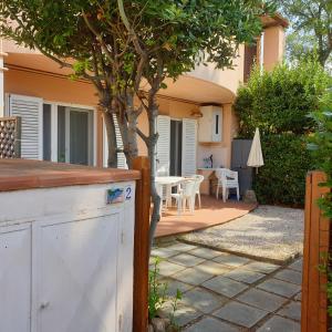 Cette maison dispose d'une terrasse avec une table et un arbre. dans l'établissement Accogliente casa indipendente a 10 min dal mare, à Castiglione della Pescaia