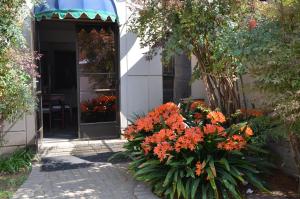 a flower garden in front of a house with orange flowers at Hydro Guesthouse in Bloemfontein