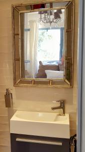 a bathroom with a sink and a mirror and a window at Maison de Thau in Mèze +21 photos