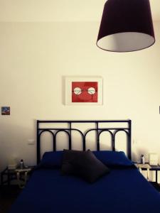 um quarto com uma cama azul e um candeeiro em Silibardi em Agrigento