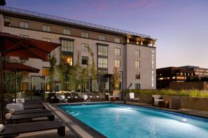 un hotel con piscina di fronte a un edificio di Hyatt Place Pasadena a Pasadena