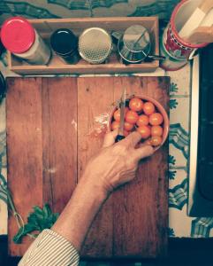 uma pessoa segurando uma tigela de tomates numa mesa em Silibardi em Agrigento