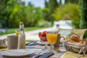 una mesa con comida y bebida y una cesta de fruta en La Demeure de Cybele - chambres d'hôtes en Drôme Provençale, en Colonzelle