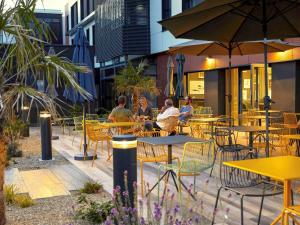 un grupo de personas sentadas en mesas en un restaurante en Aparthotel & Spa Adagio Vannes en Vannes