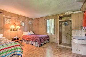 1 dormitorio con 2 camas y paredes de madera en Lovely Lake Cabin Boat Rentals and On-Site Bar, en Dent