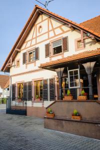 ein Gebäude mit Fenstern und Topfpflanzen auf einer Straße in der Unterkunft Hôtel Restaurant La Couronne in Roppenheim