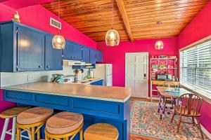 una cocina con paredes azules y rosas y techos de madera. en Vibrant PCB Bungalow with Patio - Walk to the Beach!, en Panama City Beach