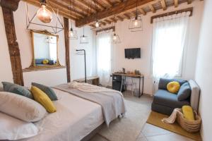 a bedroom with a bed and a chair and a mirror at Luna Sul Tetto in Carpi