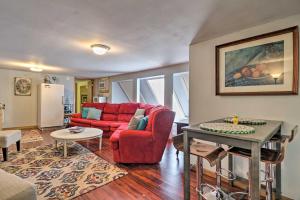 a living room with a red couch and a table at Riverfront Townsend Apt - 18 Miles to Pigeon Forge in Townsend