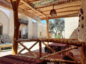 a large bed in a room with a wooden roof at madrasah Polvon-Qori boutique in Khiva