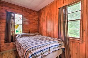 a bed in a room with wooden walls and windows at Lake Retreat Fire Pit, Boat Rentals, BBQ! in Dent