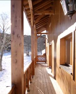 une terrasse couverte d'un bâtiment en bois dans la neige dans l'établissement Biches du Plantin, à Les Allues