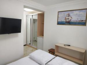um quarto com uma cama e uma televisão de ecrã plano em Shaarei Zion em Uman