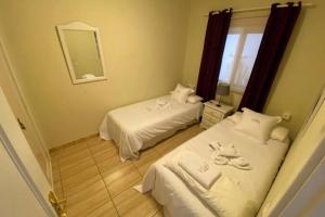 a hotel room with two beds and a mirror at Apartamento El Poril in Tías