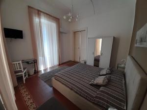 um quarto com uma cama e uma televisão em Casa Polena em Catânia